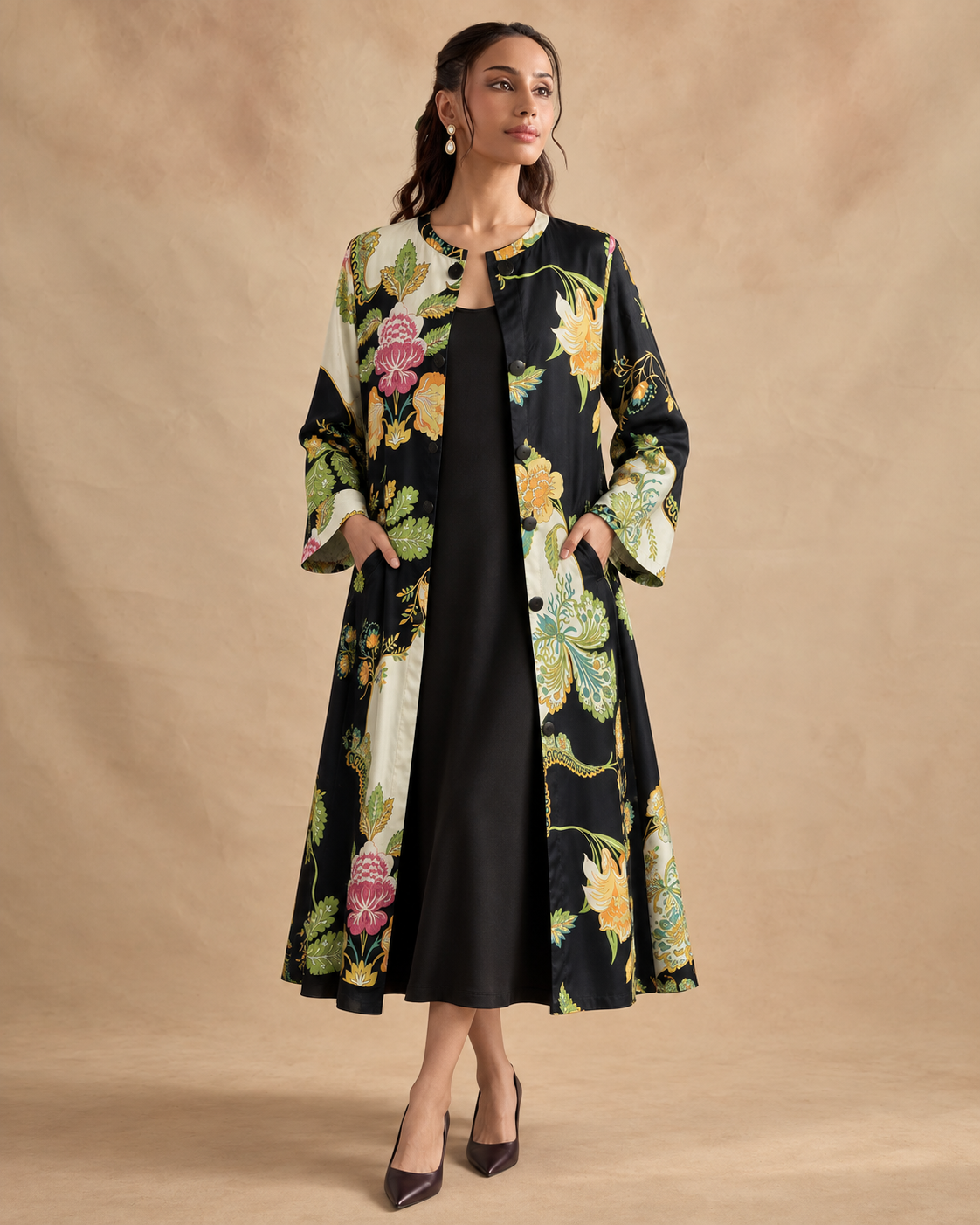Vanika by House of Somarra — Walking view of the black midi-length dress and botanical panels.