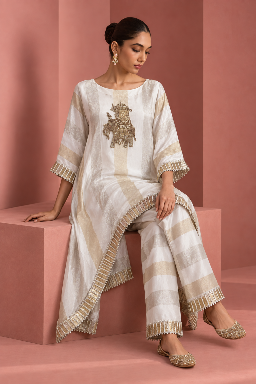 Kashvi by House of Somarra — Seated view showing the striped trousers and asymmetric kaftan hem.