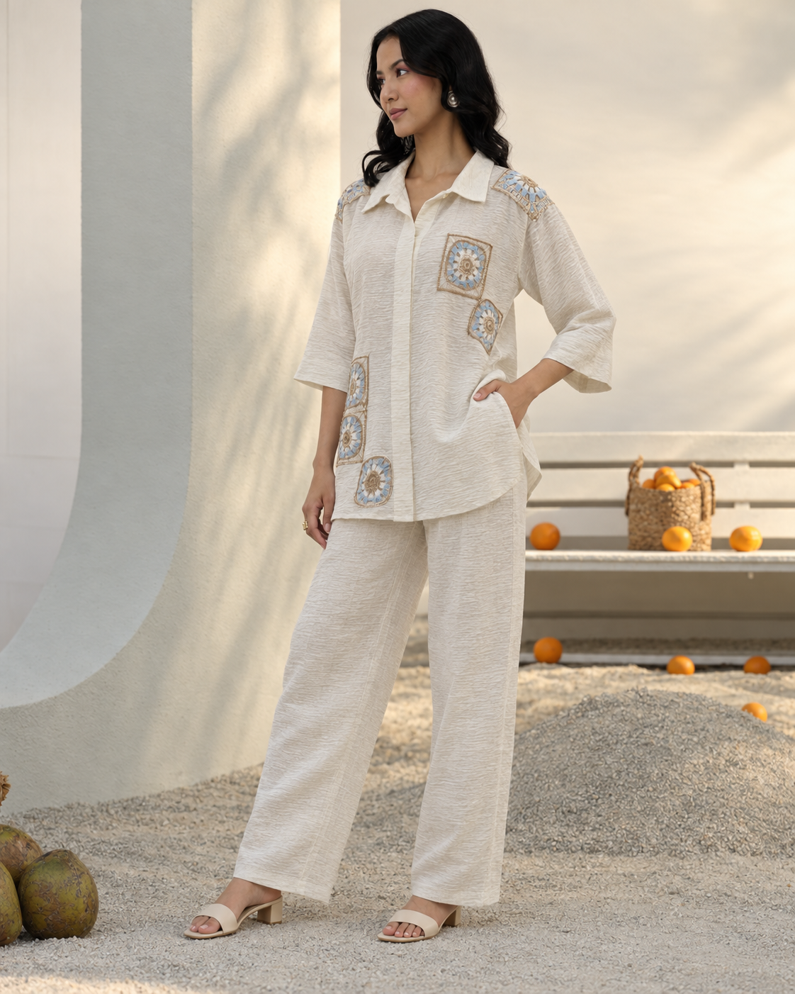 Mihira by House of Somarra — Side view showing the loose cream shirt and straight trousers.