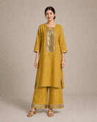 Aabha gold-mustard pure-linen co-ord suit, full front view with antique-shimmer yoke and mirror-lace trim.