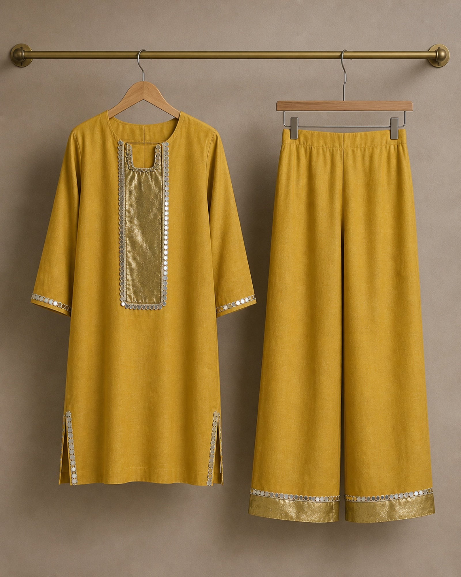 Aabha gold-mustard linen shirt and palazzo displayed separately on hangers, showing mirror-lace and antique-shimmer details.