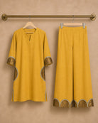 Hanger packshot of the Arpita golden-mustard pure-linen shirt and palazzo, showing the semicircle antique-shimmer and mirror-lace details