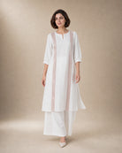 Aurelle white linen co-ord set in motion, with rose-gold-colour front trim and matching broad linen palazzos