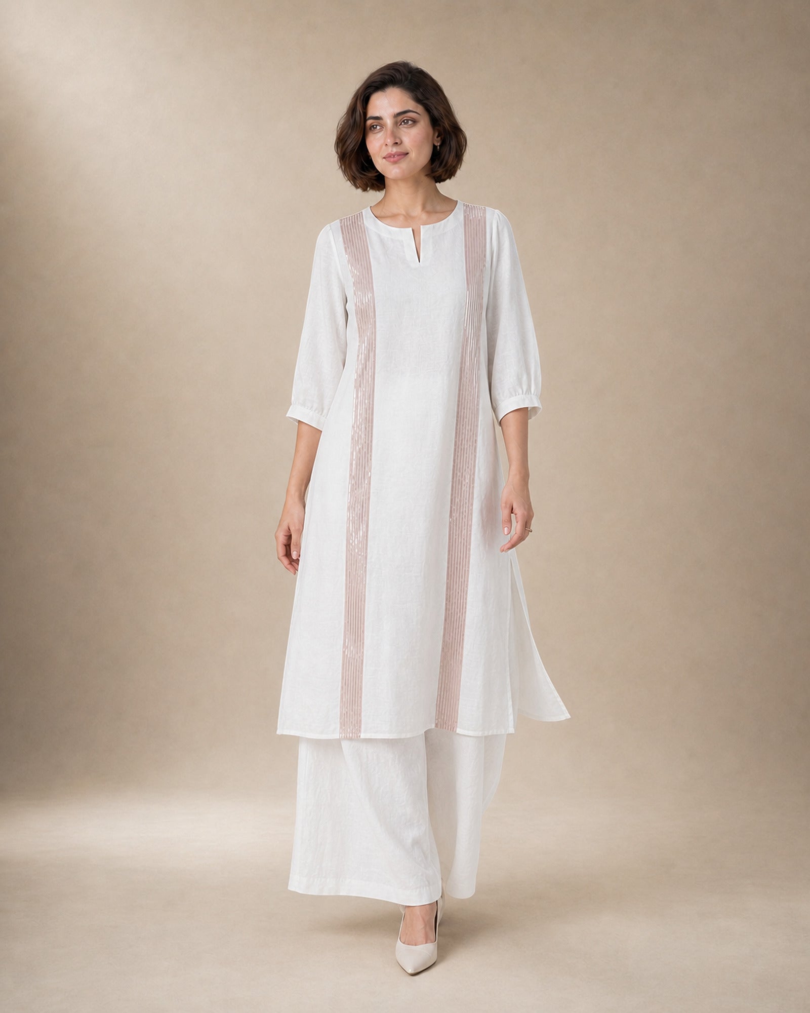 Aurelle white linen co-ord set in motion, with rose-gold-colour front trim and matching broad linen palazzos