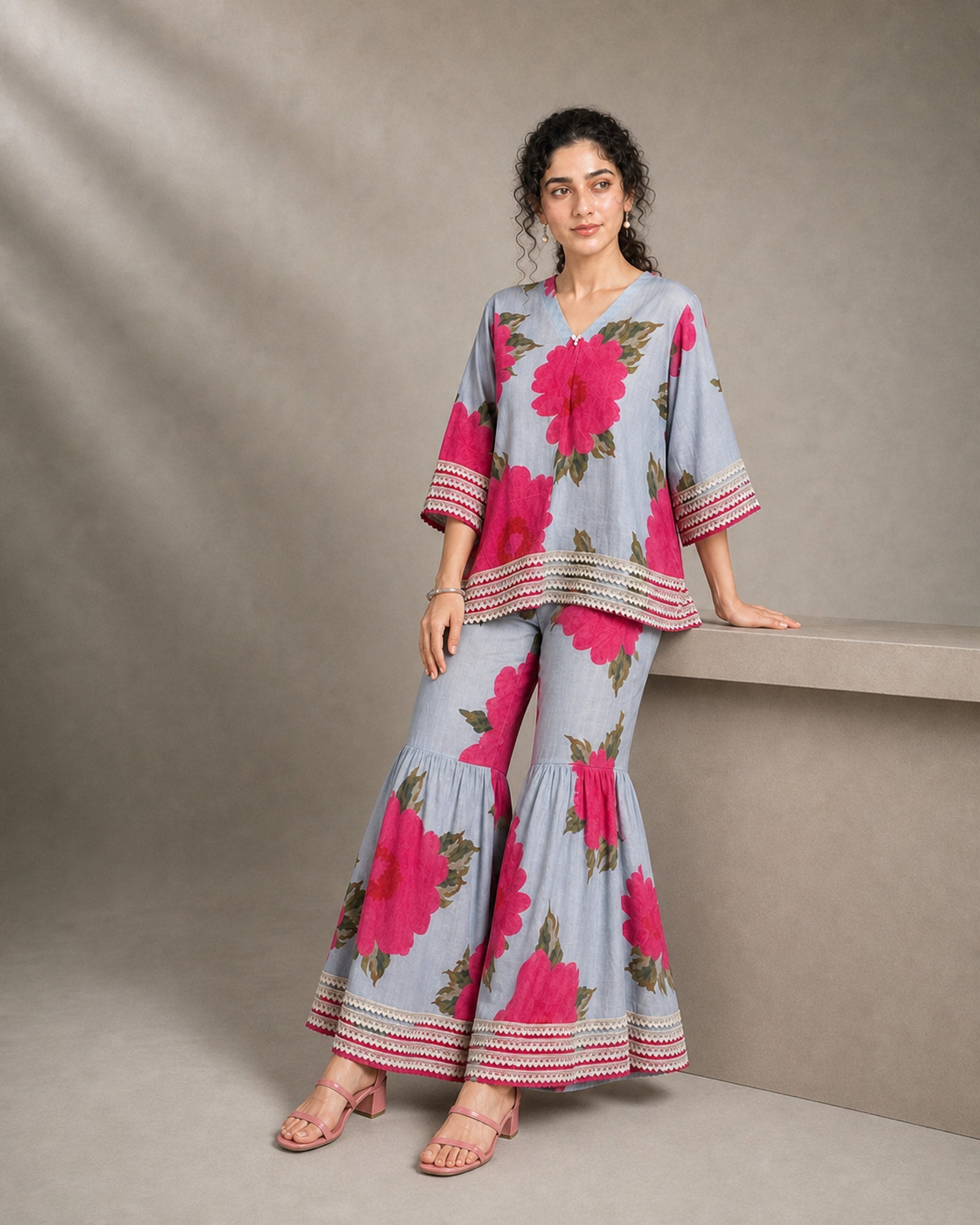 Gulaira bold pink floral lace garara co-ord set – low-block seated drape view