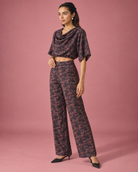 Avira by House of Somarra — Side view of the dark patterned cowl top and matching trousers.