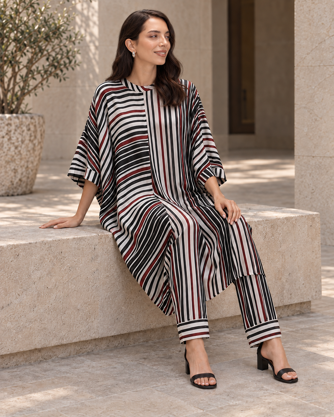 Vayra by House of Somarra — Seated view showing the striped cowl and matching trousers.