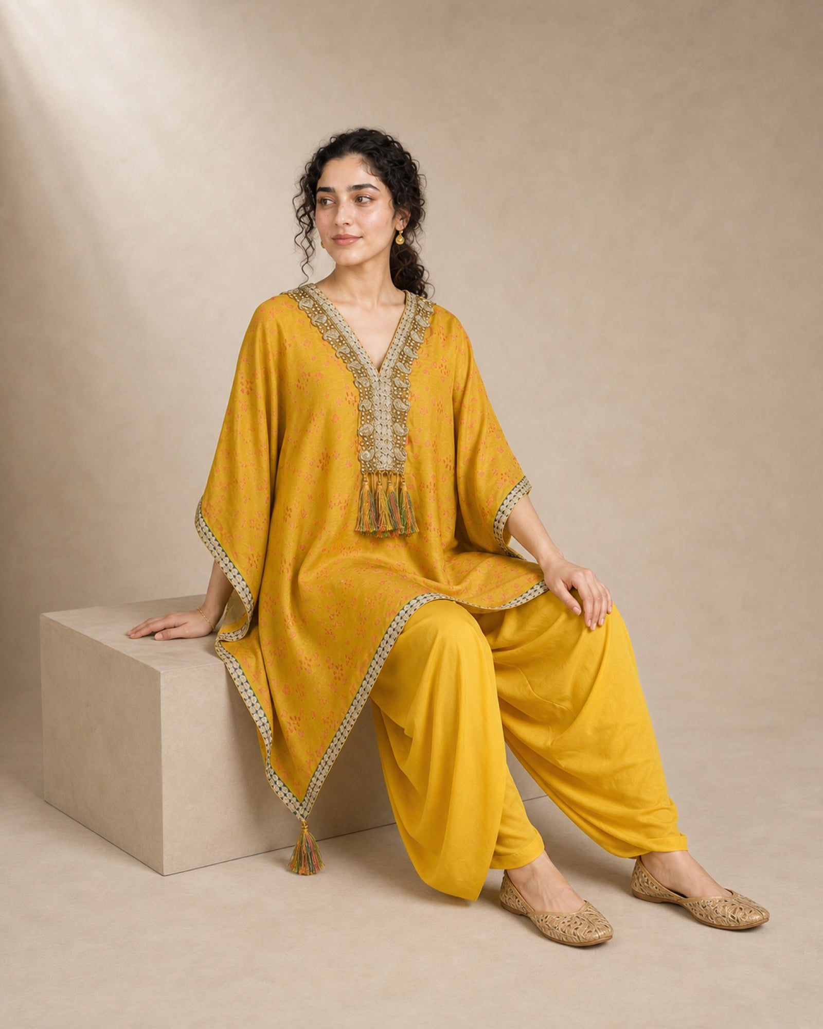 Seated view of the Sunehri yellow tie-dye Chanderi silk kaftan set, showing the cowled mul-cotton dhoti and front yoke