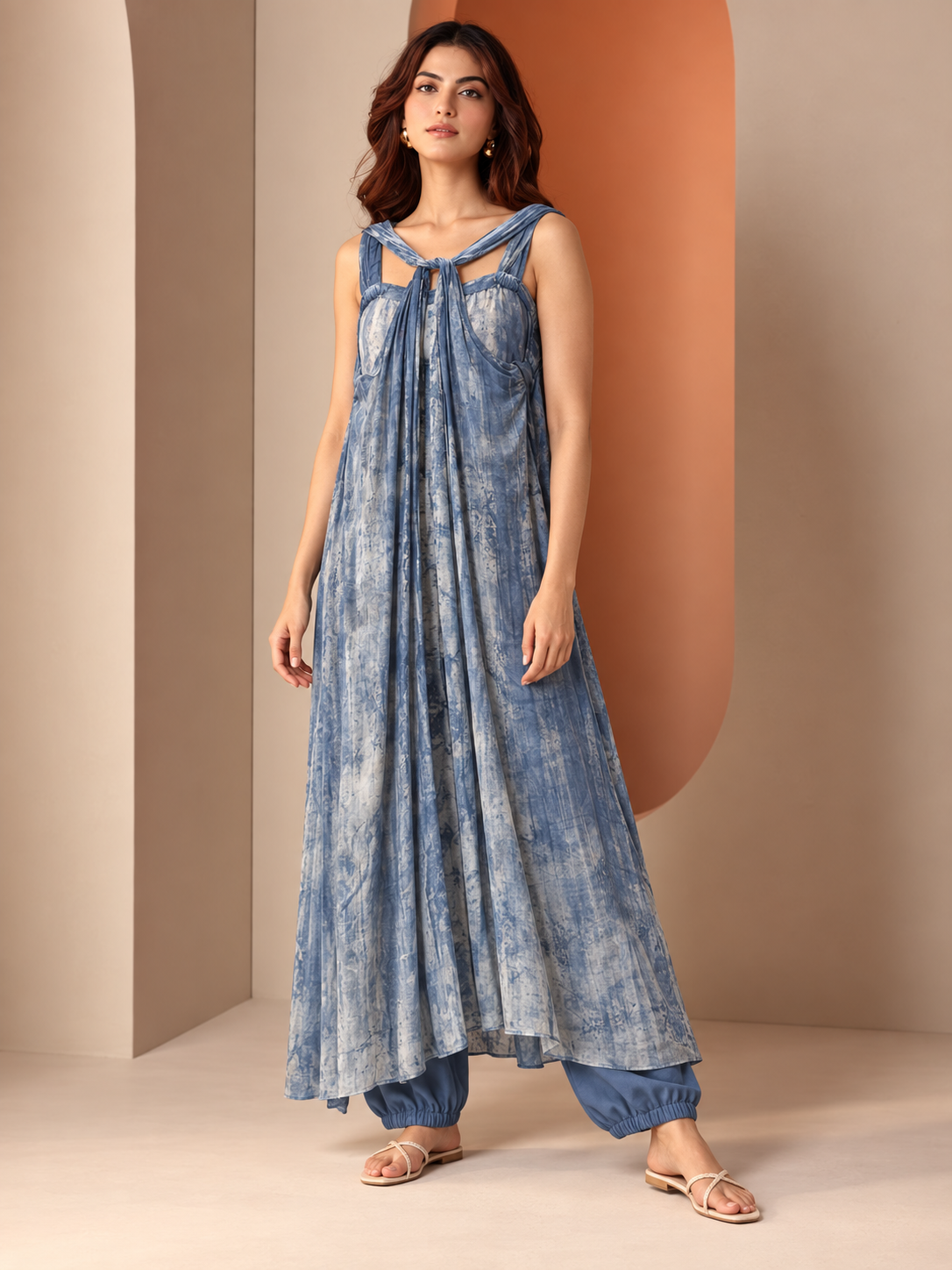 Tisya by House of Somarra — Full-length front view of the blue tie-dye dress layered over trousers.