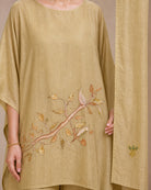 Close-up of Taru’s lower-front branch-and-leaf appliqué and a small botanical appliqué motif on the solder-beige stole