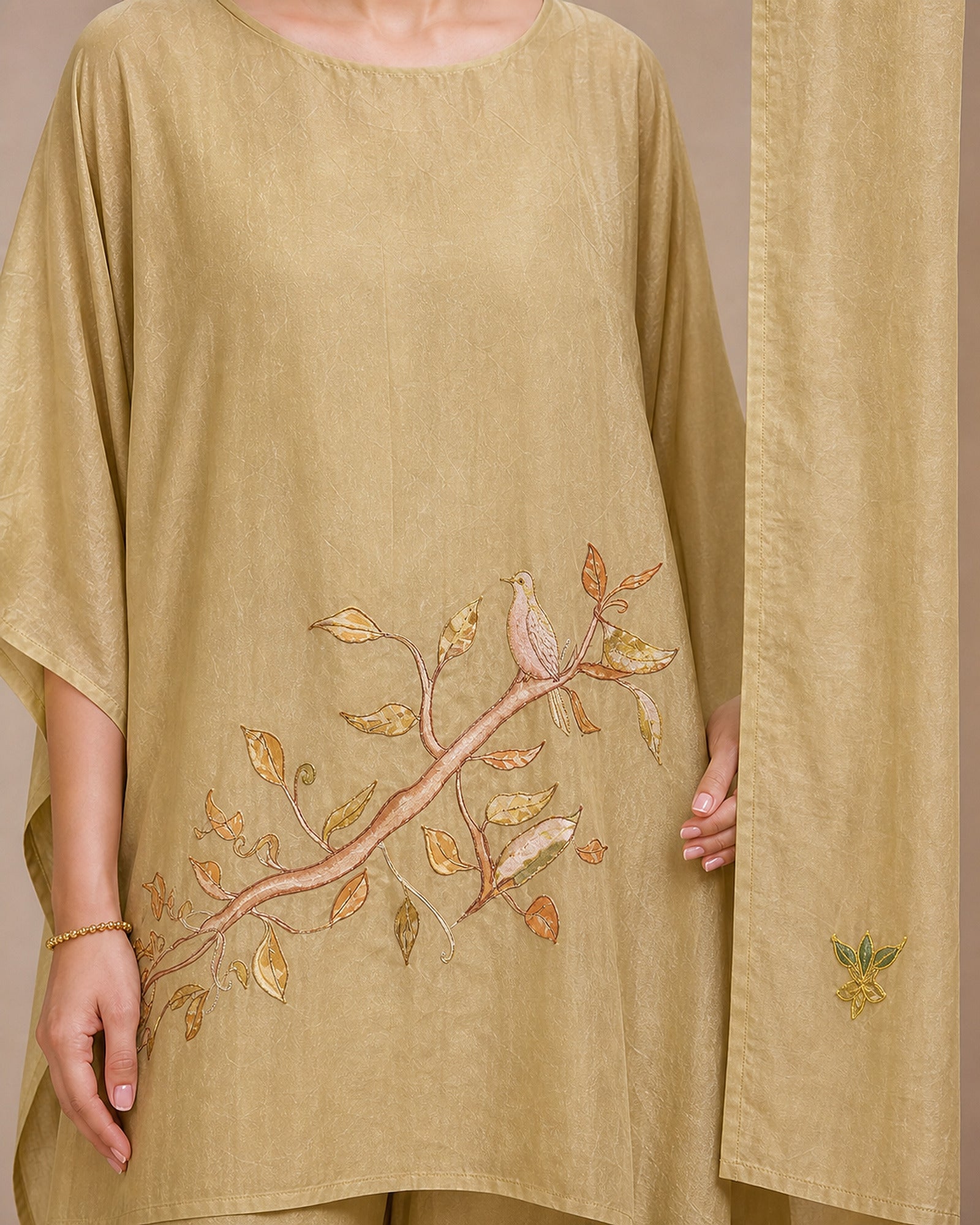 Close-up of Taru’s lower-front branch-and-leaf appliqué and a small botanical appliqué motif on the solder-beige stole