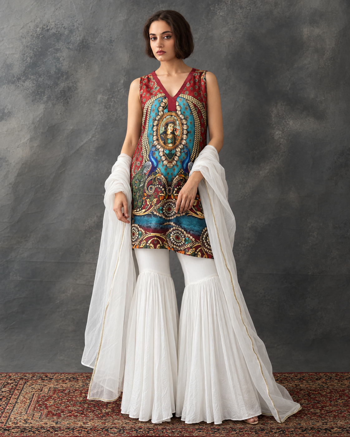 Meenal by House of Somarra — Front view of the multicoloured peacock-motif top, white flared pants and sheer stole.