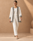 Aaina by House of Somarra — Walking view of the ivory ensemble and embroidered jacket trim.