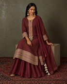 Kyra by House of Somarra — Seated view showing the wine-coloured outfit and bordered hem.