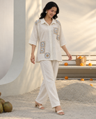 Mihira by House of Somarra — Walking view of the cream shirt and matching trousers.